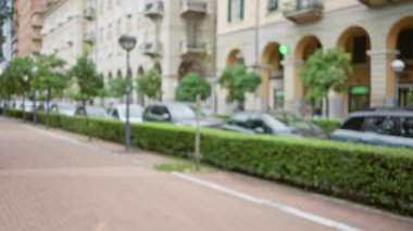 La Spezia 'daki kentsel sokak sahnesi, kaldırımda dizili arabalar ve ağaçlarla dolu, bulutlu bir gökyüzü altında Avrupa mimarisi sergileniyor..