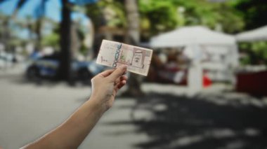 Suudi Arabistan riyal parasıyla güneşli bir şehir sokağında şehir yaşamını ve ticaretini gösteren bulanık bir geçmişe sahip..