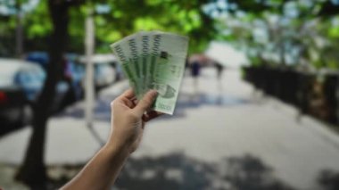 Güney Kore 'yi elinde tutan adam, bulanık şehir çevreleri arasında yakalanan bir şehir caddesinde açık havada para kazandı. Gündüz vakti finansal temaları ve şehir yaşam tarzını gözler önüne serdi..