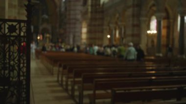 Kilisenin içi bulanık. İnsanlar loş ışığın altında bankların etrafında dolanıyor. Dini mekanların mimari güzelliğini vurguluyorlar..
