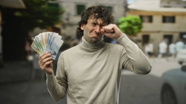 Güney Kore banknotlarını elinde tutan İspanyol bir adam tatmin olmamış görünüyor, gizli bir şehir manzarası parasıyla ilgili bir anı yakalıyor..