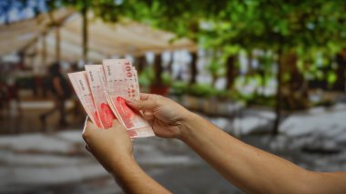 Kentsel bir caddede Tayvan dolarlarını elinde tutan adam, şehir ortamının ortasında iş ve yatırım fırsatlarını sergiliyor..