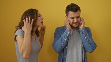 Sarı arka planda elleri kulakları olan bir adama bağıran bir kadın ilişki çatışmasını ve hayal kırıklığını gösteriyor.