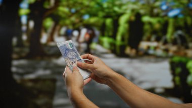 Güney Afrika Rand 'ini elinde tutan adam şehir parkının dış cephesinde iş ve finansal konsepti tasvir eden bulanık şehir sokak sahnesi kuruyor..