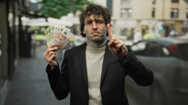 Bir şehir caddesinde uzanan parmaklarıyla Arjantin pezosu tutan İspanyol bir adam bir anlık iş ve açık hava odaklarını yakalıyor..