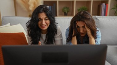 Sıcak bir oturma odasında duygusal tepkiler veren televizyon izleyen kadınlar, kapalı bir ortamda aile veya arkadaşlar arasındaki yakın bağı ve bağlantıyı gösteriyorlar..