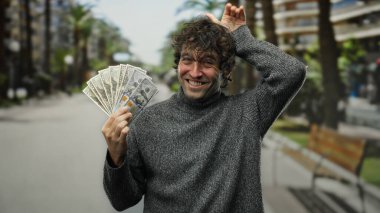 Bir şehir caddesinde gülümseyen ve elinde Amerikan doları tutan İspanyol bir adam, şehir içinde heyecan ve zenginlik sergiliyor..