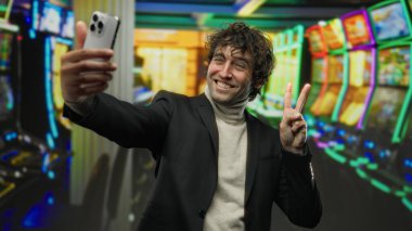 Genç İspanyol kumarhanede kumar makineleriyle çevrili bir yerde zafer jesti yapıyor. Bir anlık heyecan ve şans yakalıyor..