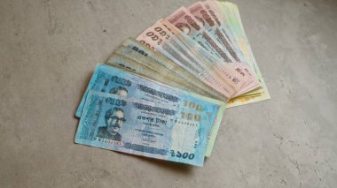 Bangladeş banknotları, Taka da dahil olmak üzere, çeşitli mezheplerde sert beton bir yüzeye yayılarak, bangladeş 'in para birimini resmediyor..
