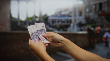 Kentsel caddede İsviçre banknotları tutan adam, şehir ortamlarında finans ve yatırım olanaklarını simgeliyor.