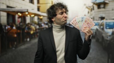 Şehrin arka bahçesinde restoranları olan bir terasta Tayland parası elinde tutan bir adam açık şehir ortamına güvenir..