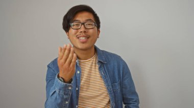 Beyaz arka planda el kol hareketleri yapan yakışıklı Asyalı genç adam.