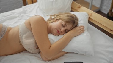 Rahat bir yatak odasında, beyaz bir yatakta huzur içinde uyuyan bir kadın, rahat, çekici özelliklerini vurgulayan doğal ışıkla sakin bir iç mekan atmosferi sergiliyor..