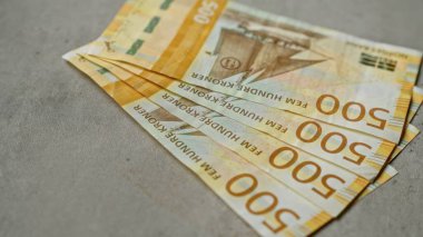 500 kronluk banknotların yer aldığı Norveç banknotları, mali bağlamda önemli para birimi ve finans temaları vurgulanarak somut bir yüzeye dayanmaktadır..