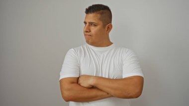Kolları çapraz duran yakışıklı İspanyol genç adam izole edilmiş beyaz arka plan ve tarafsız ifade