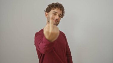 Kırmızı gömlekli genç adam, beyaz bir arka planda elleri izole bir şekilde kaba bir jest yapıyor..