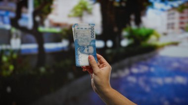 Bir şehir caddesinde el ele tutuşan Şili pesoları, açık havada bir şehirde erkek varlığıyla yatırım ve iş kavramları vurgulanıyor.