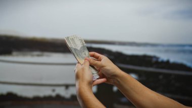 Endonezya 'nın deniz kenarındaki paralarını sayan bir adamın elleri, Endonezya' nın canlı bir sahil kasabasında iş yapmayı ve seyahat etmeyi öneriyor..