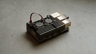 Çift soğutma vantilatörleri ve kablolu bağlantıları modern, teknik bir temayı yakalayan beton bir yüzey üzerindeki elektronik tek kartlı bilgisayar.