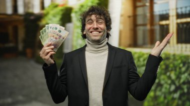 Latin asıllı bir adam şehir sokaklarında elinde Arjantin pezosu tutarak gülümsüyor. Finansal başarı ve şehir yaşam tarzını gözler önüne seriyor..