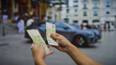 Bulanık bir araba ve şehir geçmişi olan, mali işlemleri ve açık hava yatırımlarını gösteren şehir sokaklarında tek başına dolar sayan bir adam..