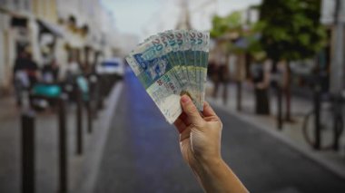 Kentsel bir sokak ortamında el ele tutuşan Hong Kong doları, mali yatırımı ve açık havadaki dövizi sembolize ediyor..