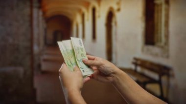 Kapalı bir ortamda Türk lira banknotlarını sayan, el ve para birimine odaklanan, finans, iş, yatırım ve para yönetimi temaları öneren adam.