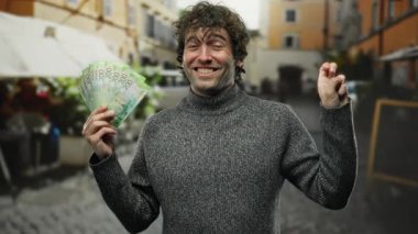 Şehir sokaklarında elinde banknotlar tutan bir adam Rusya 'da para akışını yüzünde gülümsemeyle gösteriyor..