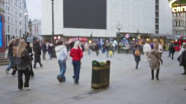 Kışlık paltolu kalabalık, arka planda ikonik mimari ile Birleşik Krallık 'ta kalabalık bir Londra caddesinde yürüyor..