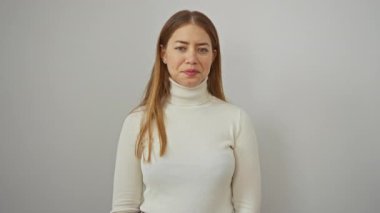 Beyaz balıkçı yakalı bir kazakla arka planda selam veren kadın, dostça bir selamlama yapıyor..