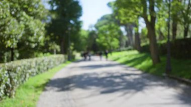 Bulanık, güneşli yol villa borghese 'de, Roma' da, insanların canlı yeşil ağaçların ve yemyeşil bahçelerin arasında yürüdüğü, cennetli bir açık hava yakaladığı, yazın huzurlu bir ortam..