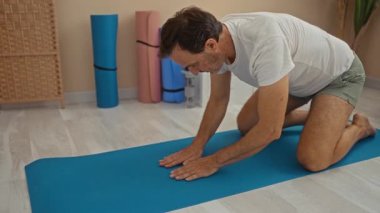Mavi minder üzerinde yoga yapan bir adam huzurlu spa odasında rahatlama, sağIık, denge, kapalı alan, esneme, yetişkin, sağlıklı, erkek, barışçıl, egzersiz sergiler..