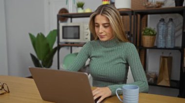 Ofis ortamında dinlenen bir kadın dizüstü bilgisayarını kapatıyor. Etrafı bitkilerle ve modern dekorlarla çevrili. Masasında bir kupayla huzurlu bir çalışma ortamı sergiliyor..