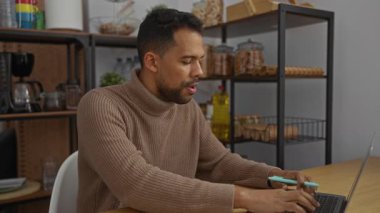 Genç İspanyol bir adam ofis ortamında kalem mikrofonla şarkı söylüyor, yaratıcılığını ve enerjisini kapalı bir iş ortamında sergiliyor..