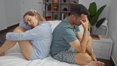 Yatak odasında sırt sırta oturan çift duygusal uzaklık ve ilişki gerginliği ifade ediyor..