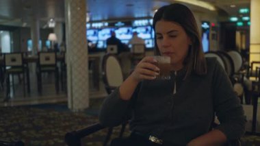 Evin içinde içmekten hoşlanan kadın şık dekorlu ve sofistike atmosferli lüks bar atmosferiyle çevrili..