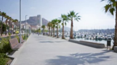 Bulanık figürler ve güneşli bir sahil manzaralı marina arkaplan ile odaklanmış avuç içi çizgili gezinti.