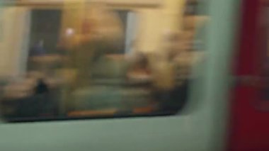 Odaklanmamış görüntü, Londra yeraltı treninin içindeki bulanık banliyö sakinlerini görüntüler. Bokeh etkisi yaratarak hareket ve kentsel ulaşım atmosferini vurgular ve tüp deneyimini vurgular..