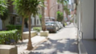 Bulanık arka plan, bokeh ağaçları, arabalar ve binalar ile bulanık sokak sahnesi rüya gibi, odak dışı bir etki yaratıyor..
