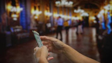 Kilisenin iç kısımlarında bulanık insanlar ve avizelerle birlikte Malezya ringgit 'i tutan adam..