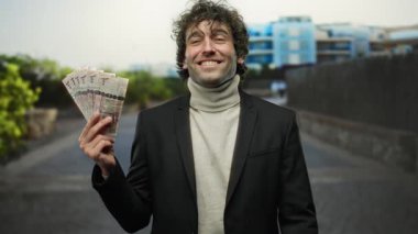 Kentin dış kesimlerinde Suudi ayinlerini düzenlerken gülümseyen İspanyol adam sokakta para gösteriyor..