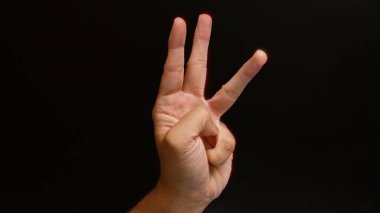 Adamın eli, arka planda üç numaralı hareketi gösteriyor.