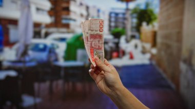 İsveç kronunun el ele tutuşması şehir terasında şehir yatırımını ve finans faaliyetlerini canlı bir kasaba atmosferiyle çevrili bir adam tarafından destekliyor..