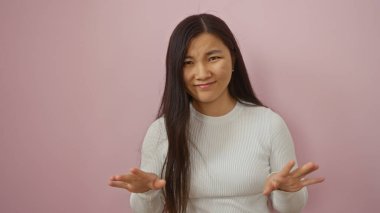 Yetişkin bir Çinli kadın model olarak pembe bir duvara gülümseyen kadın uzun saçlı neşeli bir ifade sergiliyor izole edilmiş bir stüdyo ortamında güzellik ve güveni vurguluyor..