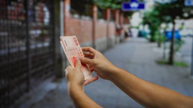 Kentsel sokak gösterilerinde Tayvan dolarları tutan adam şehrin hareketli ortamında finansal işlem yatırım kavramı.