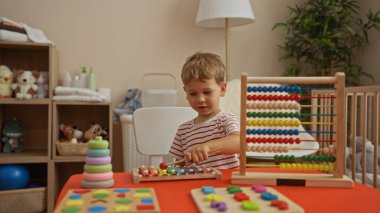 Küçük çocuk sıcak bir anaokulunda evde eğitici oyuncaklarla oynuyor.