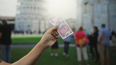 İtalya 'nın Sidikli Kulesi' nin yanında elinde Türk lirası banknotu tutan adam seyahat ve kültür ruhunu yakalıyor..