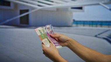 Hong Kong banknotlarını elinde tutan adam şehir dışındaki bir iş sahasına yatırım ve döviz kurunu yansıtıyor..