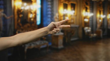 Kibar kilisenin iç kısımlarında barış jesti sergiliyor. Yumuşak ışıklandırma, dekorasyon ve bulanık arka plan ile kutsal mekanın huzur dolu sükunetini vurguluyor..