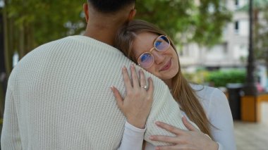 Kadın açık şehir parkı ortamında erkekleri kucaklıyor, ağaçlarla çevrili iken ilişkilerini ve aşklarını sergiliyor, sıcak ve güzel bir birliktelik sahnesi yaratıyor..